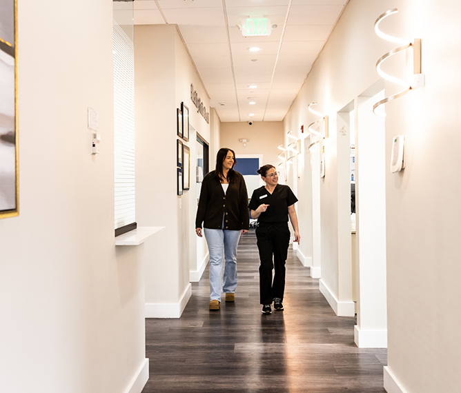 Dental team member walking a patient down the hallway