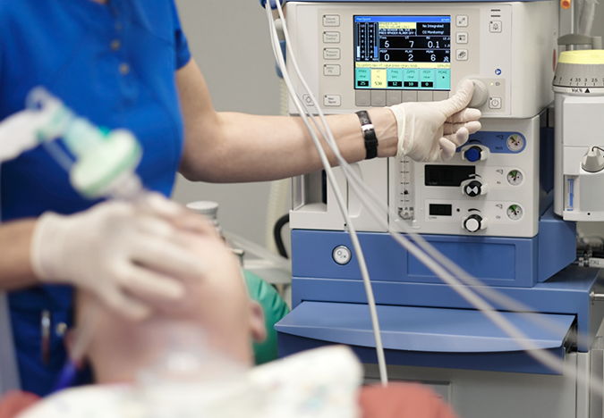Dentist adjusting a nitrous oxide machine