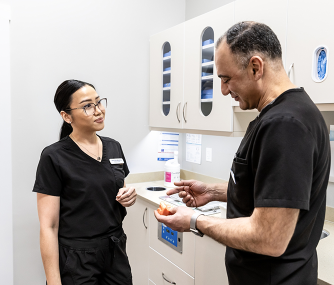 Doctor Tabbah talking to a dental team member