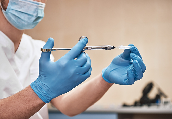 Dental professional drawing a syringe