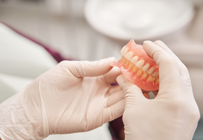 Dentist holding a set of full dentures