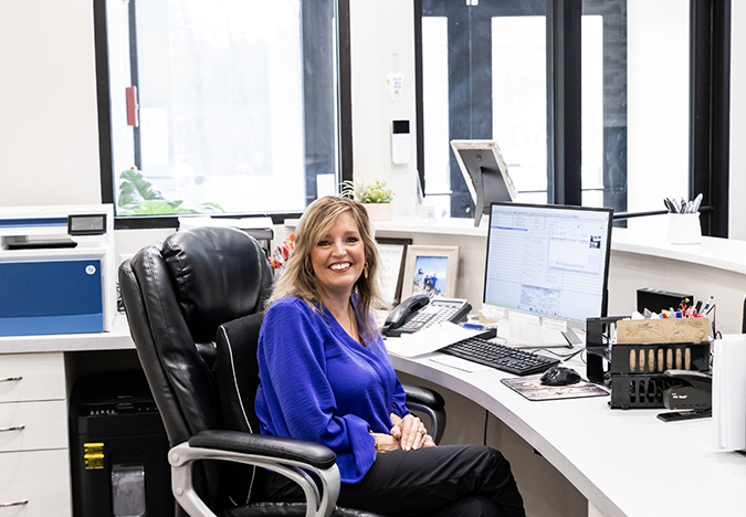 Dental team member smiling behind the front desk