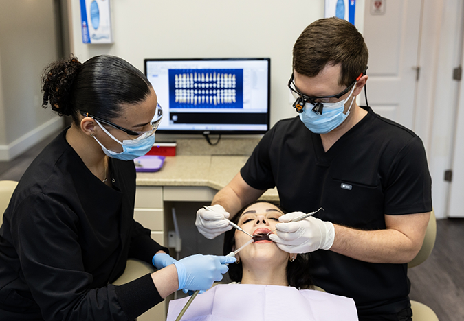 Dentist and assistant performing a treatment on a patient