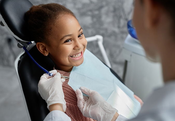 Young girl in the dental chair grinning